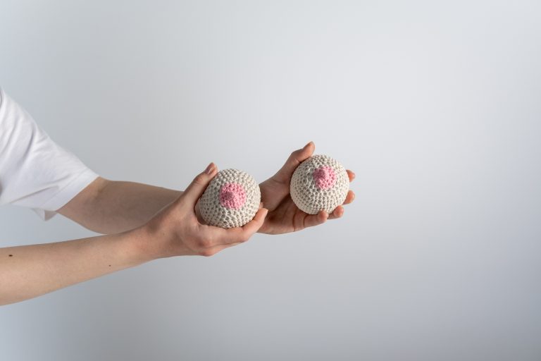 Person holding white and pink egg